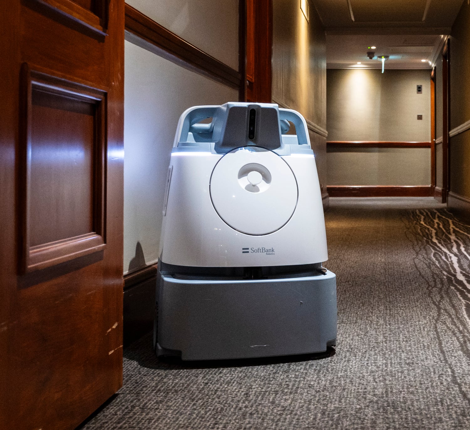 Robot vacuum cleaner in a hotel corridor.